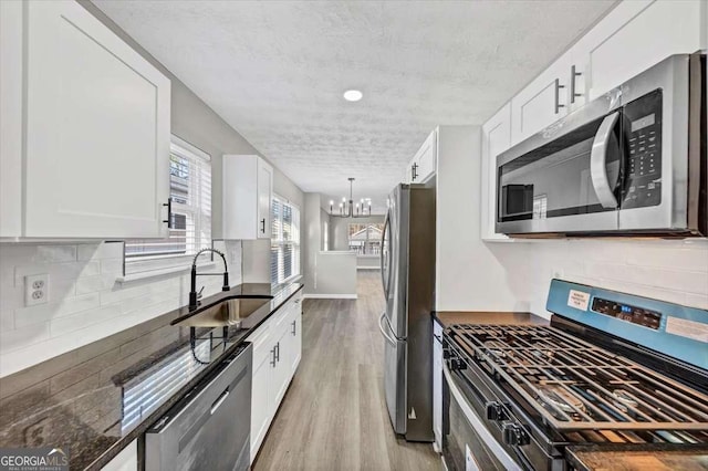 2478 Verbena Cir NW, Atlanta, GA 30314 - kitchen featuring light wood-style flooring, a notable chandelier, appliances with stainless steel finishes, and a sink