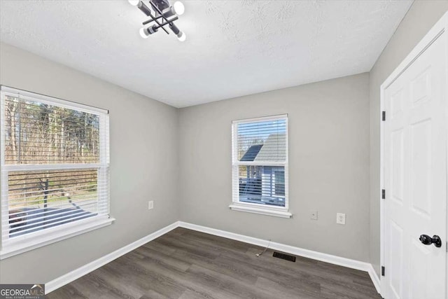2478 Verbena Cir NW, Atlanta, GA 30314 - unfurnished bedroom featuring visible vents, a textured ceiling, baseboards, and dark wood-style flooring