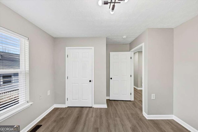 2478 Verbena Cir NW, Atlanta, GA 30314 - unfurnished bedroom featuring visible vents, baseboards, a textured ceiling, and wood finished floors