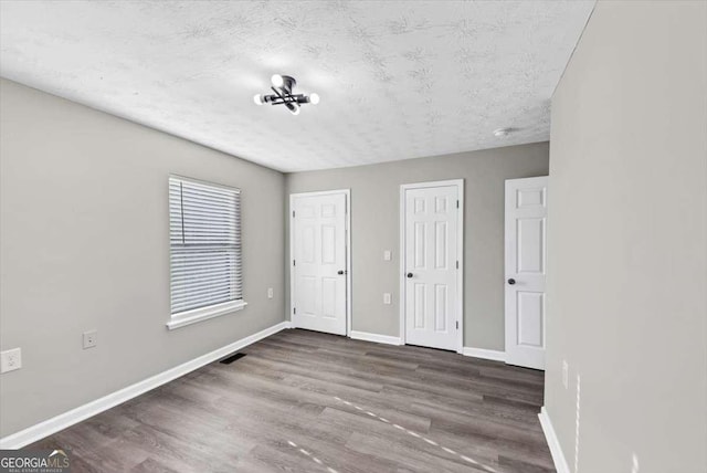 2478 Verbena Cir NW, Atlanta, GA 30314 - unfurnished bedroom featuring wood finished floors, baseboards, visible vents, and two closets