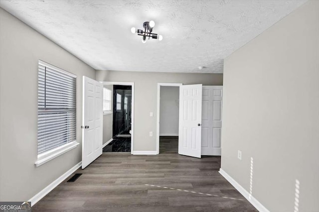 2478 Verbena Cir NW, Atlanta, GA 30314 - unfurnished bedroom featuring visible vents, a textured ceiling, baseboards, and wood finished floors