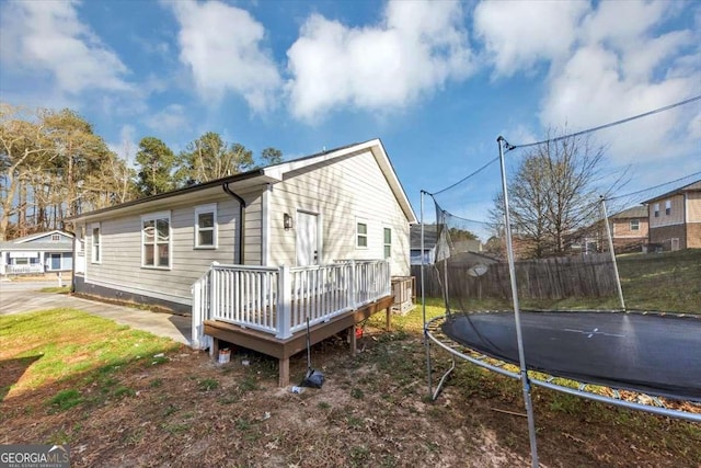 2478 Verbena Cir NW, Atlanta, GA 30314 - back of house featuring a wooden deck, a trampoline, and fence