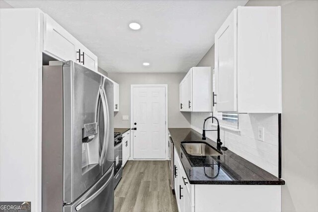 2478 Verbena Cir NW, Atlanta, GA 30314 - kitchen featuring dark countertops, light wood-style flooring, stainless steel appliances, white cabinetry, and a sink