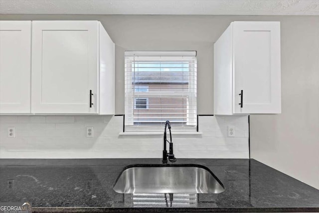 2478 Verbena Cir NW, Atlanta, GA 30314 - kitchen featuring white cabinetry, dark stone counters, backsplash, and a sink