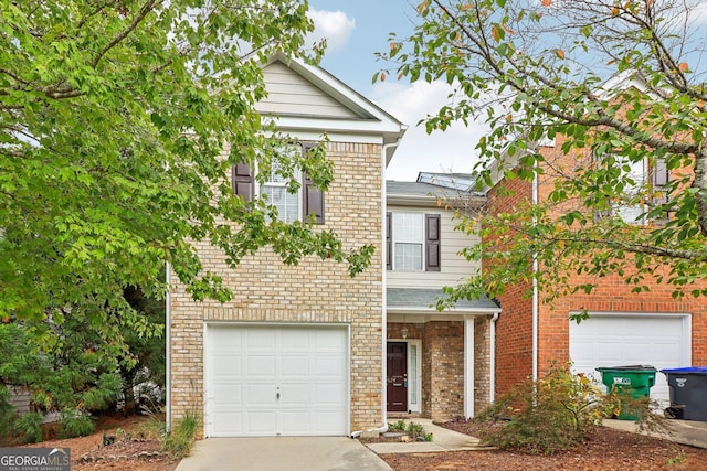 view of front of house with brick siding, an attached garage, and driveway