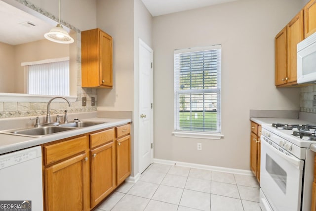 kitchen with decorative backsplash, white appliances, visible vents, and a sink