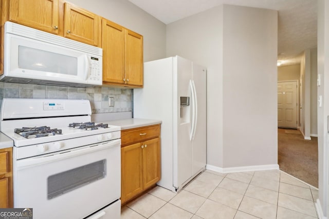 kitchen featuring tasteful backsplash, white appliances, light tile patterned flooring, light countertops, and baseboards