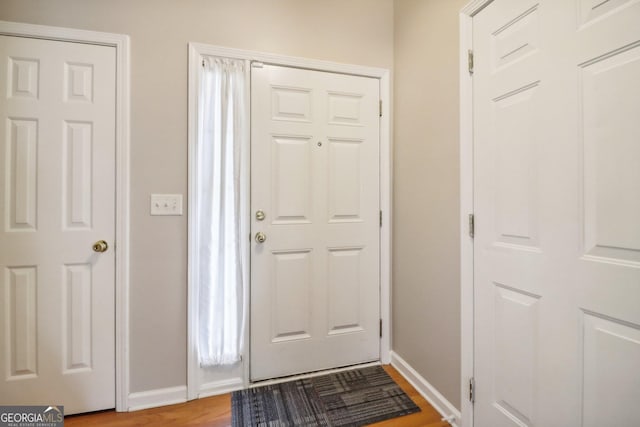 entryway with baseboards and light wood-style flooring