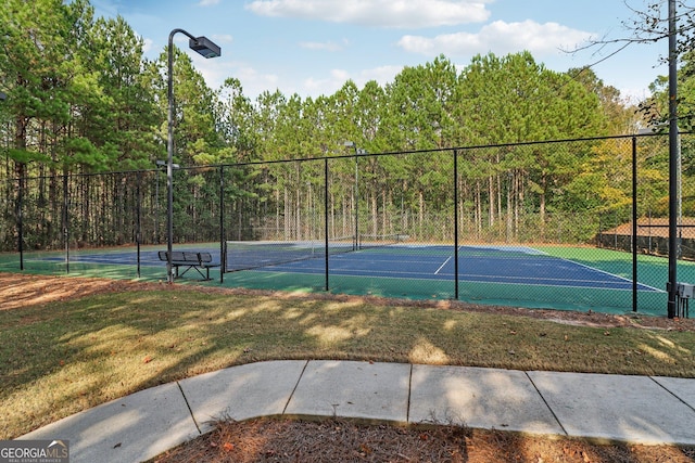 view of sport court featuring a yard and fence