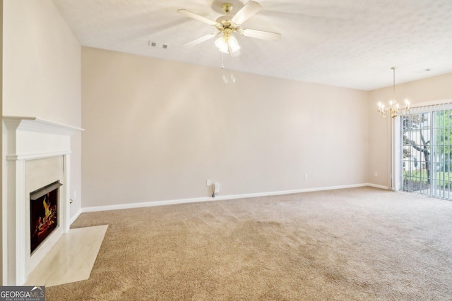unfurnished living room featuring visible vents, baseboards, carpet flooring, and ceiling fan with notable chandelier