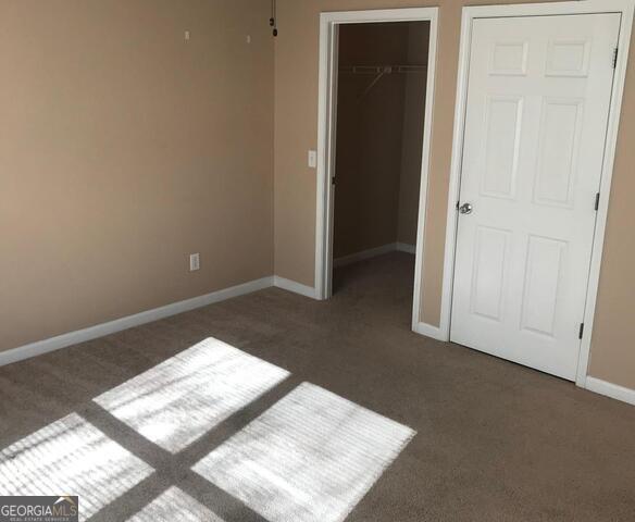 18102 Waldrop Cv, Decatur, GA 30034 - unfurnished bedroom featuring baseboards, carpet, a closet, and a spacious closet