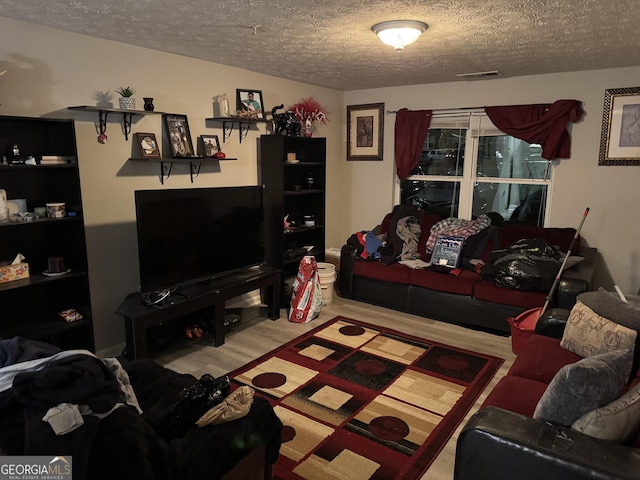 18102 Waldrop Cv, Decatur, GA 30034 - living room with wood finished floors, visible vents, and a textured ceiling