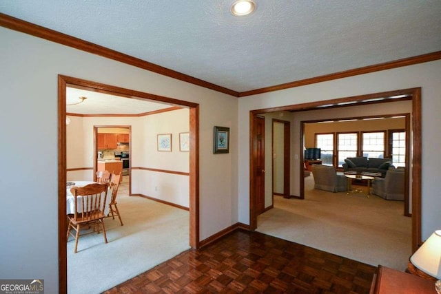 hall with dark colored carpet, crown molding, and baseboards