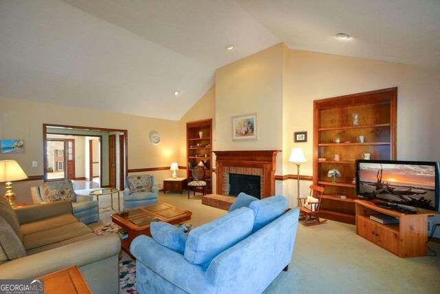 living area with lofted ceiling, a brick fireplace, carpet flooring, and built in shelves