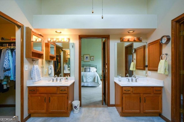 bathroom featuring two vanities, ensuite bath, and a sink