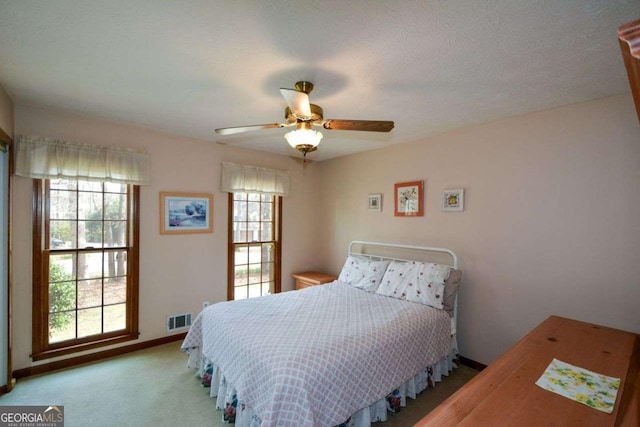 bedroom with carpet floors, visible vents, a ceiling fan, and baseboards