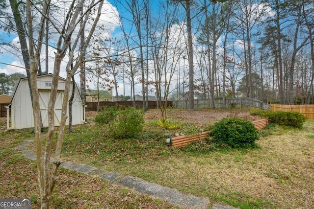 view of yard with a storage shed, fence, and an outdoor structure