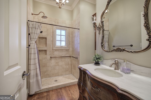 full bathroom featuring vanity, crown molding, tiled shower, and wood finished floors