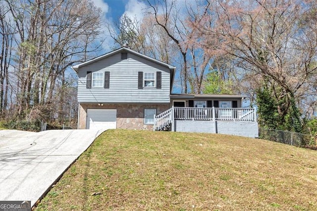 3671 Satellite Blvd, Ellenwood, GA 30294 - split level home with a front lawn, fence, concrete driveway, stone siding, and an attached garage