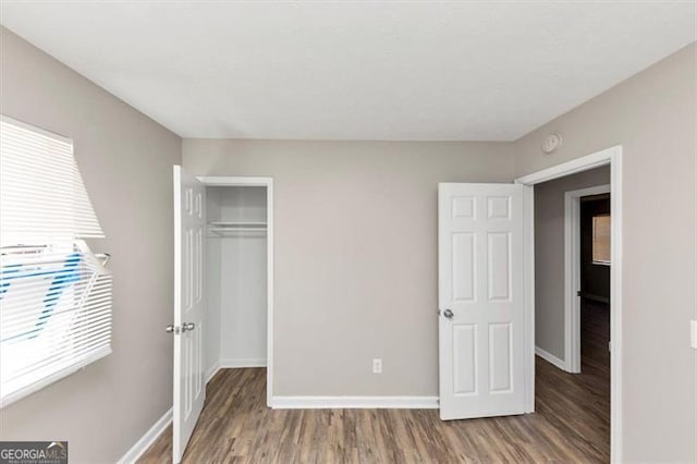 3671 Satellite Blvd, Ellenwood, GA 30294 - unfurnished bedroom featuring multiple windows, baseboards, and wood finished floors