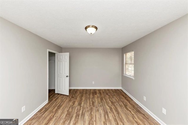 3671 Satellite Blvd, Ellenwood, GA 30294 - spare room with wood finished floors, baseboards, and a textured ceiling