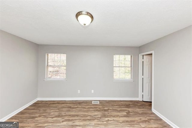3671 Satellite Blvd, Ellenwood, GA 30294 - unfurnished room with plenty of natural light, wood finished floors, and baseboards