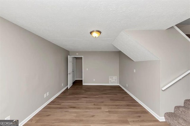 3671 Satellite Blvd, Ellenwood, GA 30294 - bonus room featuring stairway, baseboards, a textured ceiling, and wood finished floors