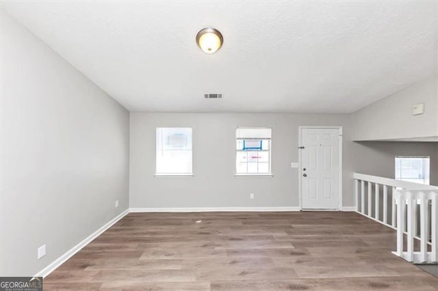 3671 Satellite Blvd, Ellenwood, GA 30294 - spare room with visible vents, baseboards, a textured ceiling, and wood finished floors
