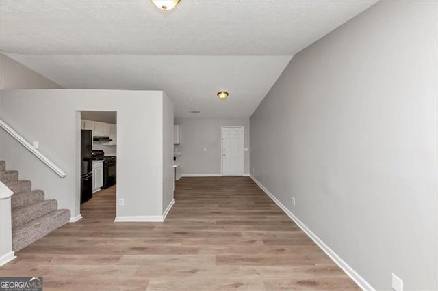 3671 Satellite Blvd, Ellenwood, GA 30294 - hallway featuring lofted ceiling, stairway, light wood-style floors, and baseboards