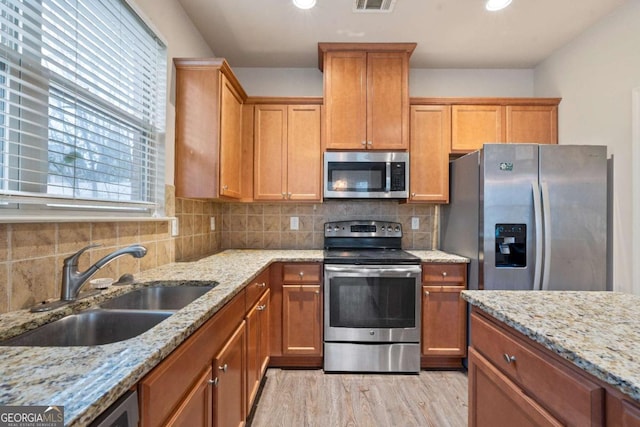 3879 Brockenhurst Dr, Buford, GA 30519 - kitchen with visible vents, light wood-type flooring, decorative backsplash, appliances with stainless steel finishes, and a sink