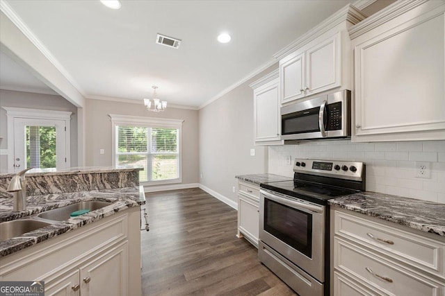 14 Carters Way, Forsyth, GA 31029 - kitchen featuring appliances with stainless steel finishes, a sink, plenty of natural light, decorative backsplash, and ornamental molding