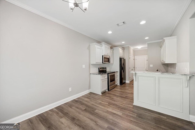 14 Carters Way, Forsyth, GA 31029 - kitchen featuring appliances with stainless steel finishes, crown molding, baseboards, dark wood finished floors, and white cabinets