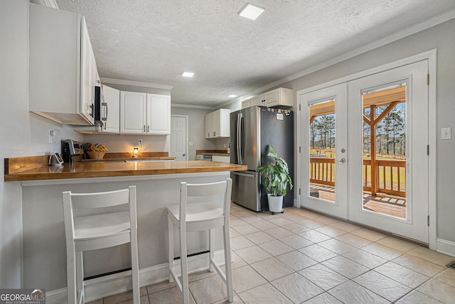 1875 Ebenezer Rd SW, Conyers, GA 30094 - kitchen with freestanding refrigerator, wooden counters, a peninsula, ornamental molding, and french doors