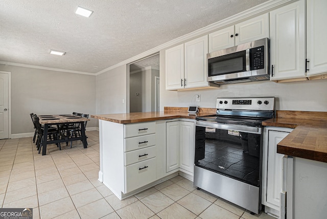 1875 Ebenezer Rd SW, Conyers, GA 30094 - kitchen featuring appliances with stainless steel finishes, wood counters, light tile patterned flooring, white cabinets, and a textured ceiling