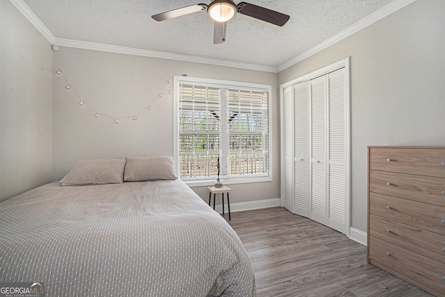 1875 Ebenezer Rd SW, Conyers, GA 30094 - bedroom with a textured ceiling, wood finished floors, a closet, crown molding, and baseboards