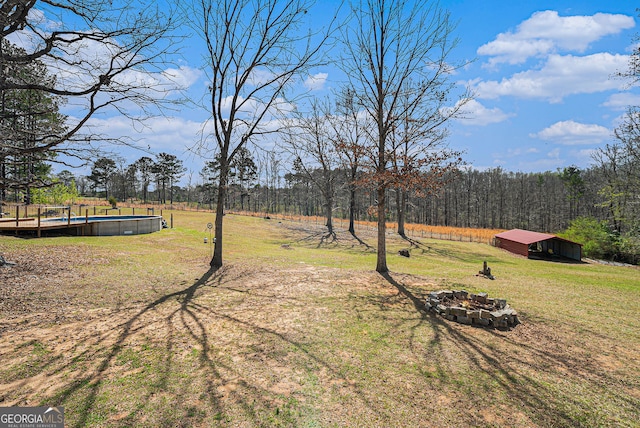 1875 Ebenezer Rd SW, Conyers, GA 30094 - view of green lawn with an outdoor pool, a wooded view, an outdoor structure, and an outbuilding