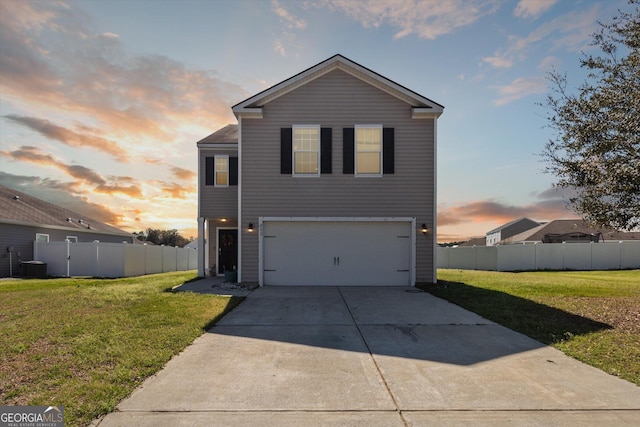 traditional-style home with a garage, driveway, a front yard, and fence