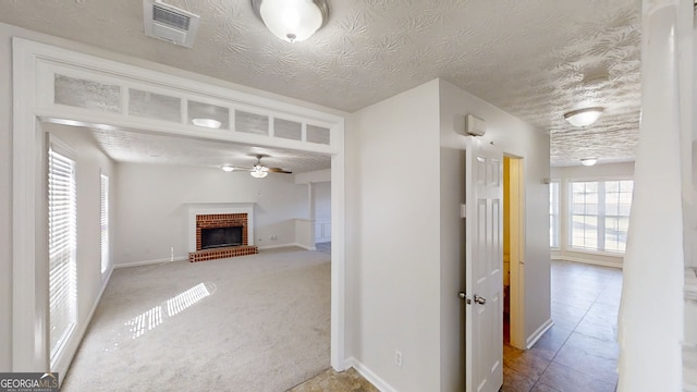 921 Dunagan Way, Lawrenceville, GA 30045 - unfurnished living room with a fireplace, ceiling fan, and a textured ceiling