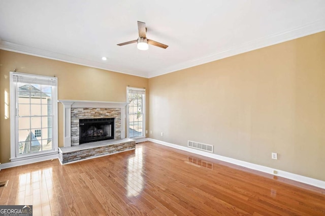 unfurnished living room with a healthy amount of sunlight, baseboards, visible vents, and ceiling fan