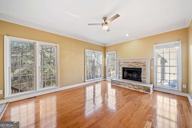 unfurnished living room featuring visible vents, a ceiling fan, hardwood / wood-style flooring, crown molding, and baseboards