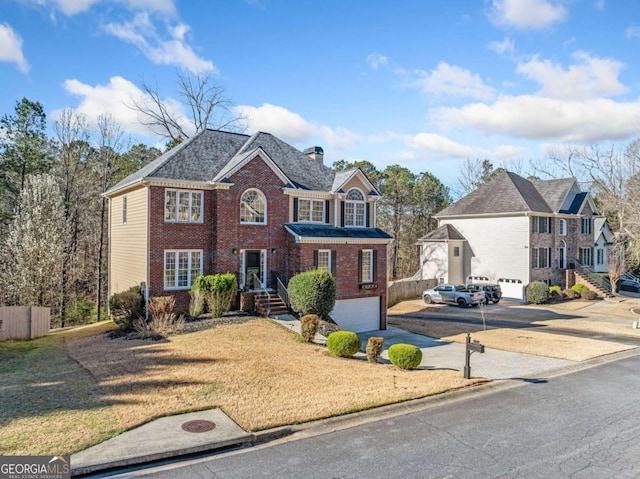 view of front facade featuring concrete driveway, a garage, brick siding, and a chimney