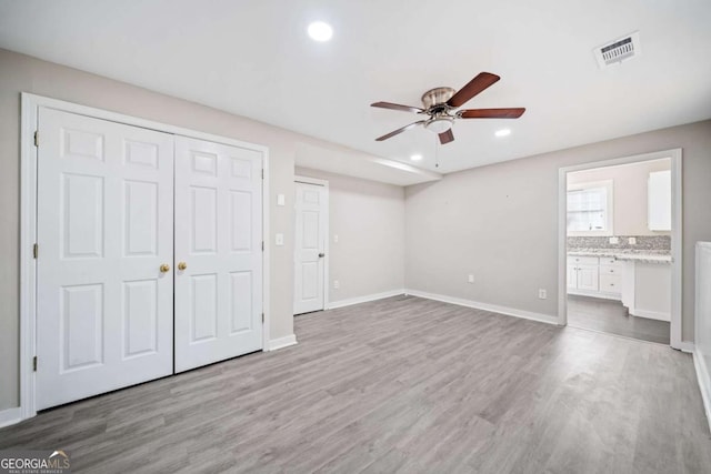 unfurnished bedroom with recessed lighting, wood finished floors, and baseboards