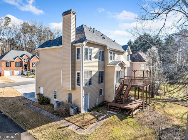 view of property exterior with a wooden deck, a chimney, central AC unit, and stairs