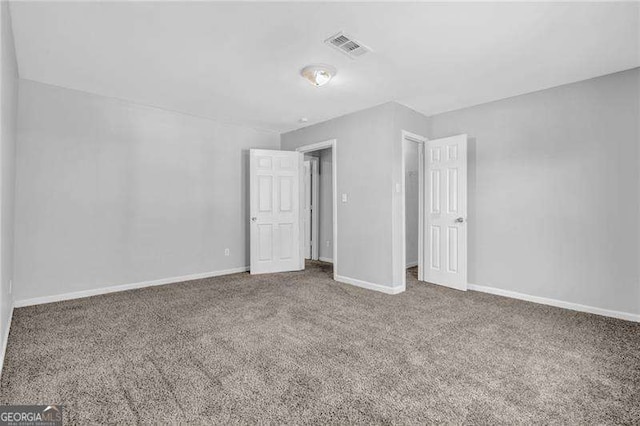 unfurnished bedroom with carpet flooring, visible vents, and baseboards
