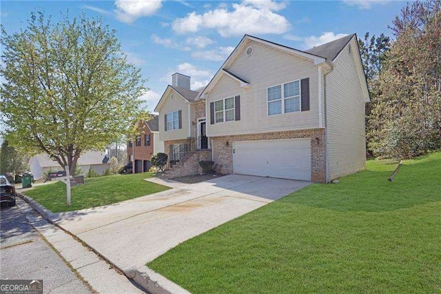 bi-level home with brick siding, an attached garage, a front lawn, a chimney, and driveway