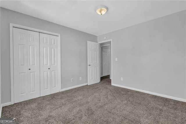 unfurnished bedroom featuring a closet, baseboards, and carpet