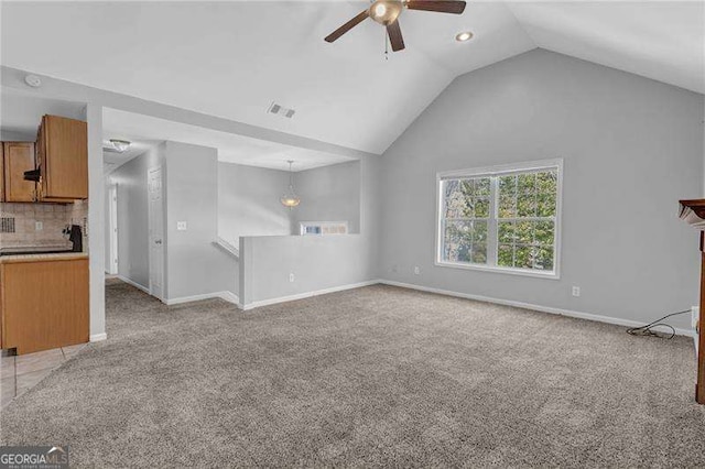 unfurnished living room featuring light colored carpet, baseboards, lofted ceiling, and ceiling fan