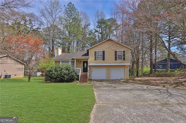 2895 Wildflower Ln, Snellville, GA 30039 - split level home featuring a chimney, a garage, concrete driveway, and a front yard