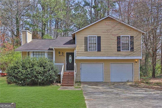 2895 Wildflower Ln, Snellville, GA 30039 - split level home featuring an attached garage, driveway, a chimney, and a front lawn