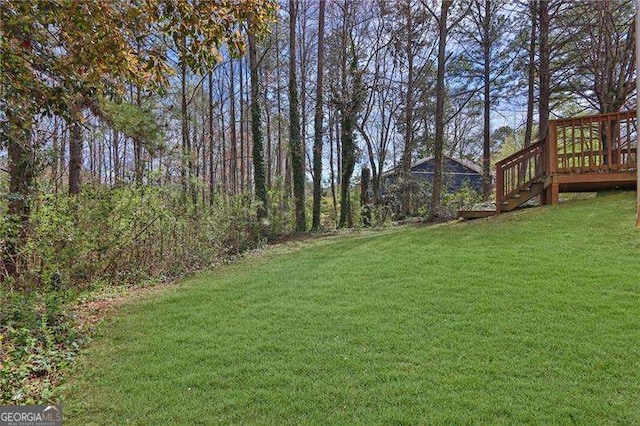 2895 Wildflower Ln, Snellville, GA 30039 - view of grassy yard with a wooden deck and stairway